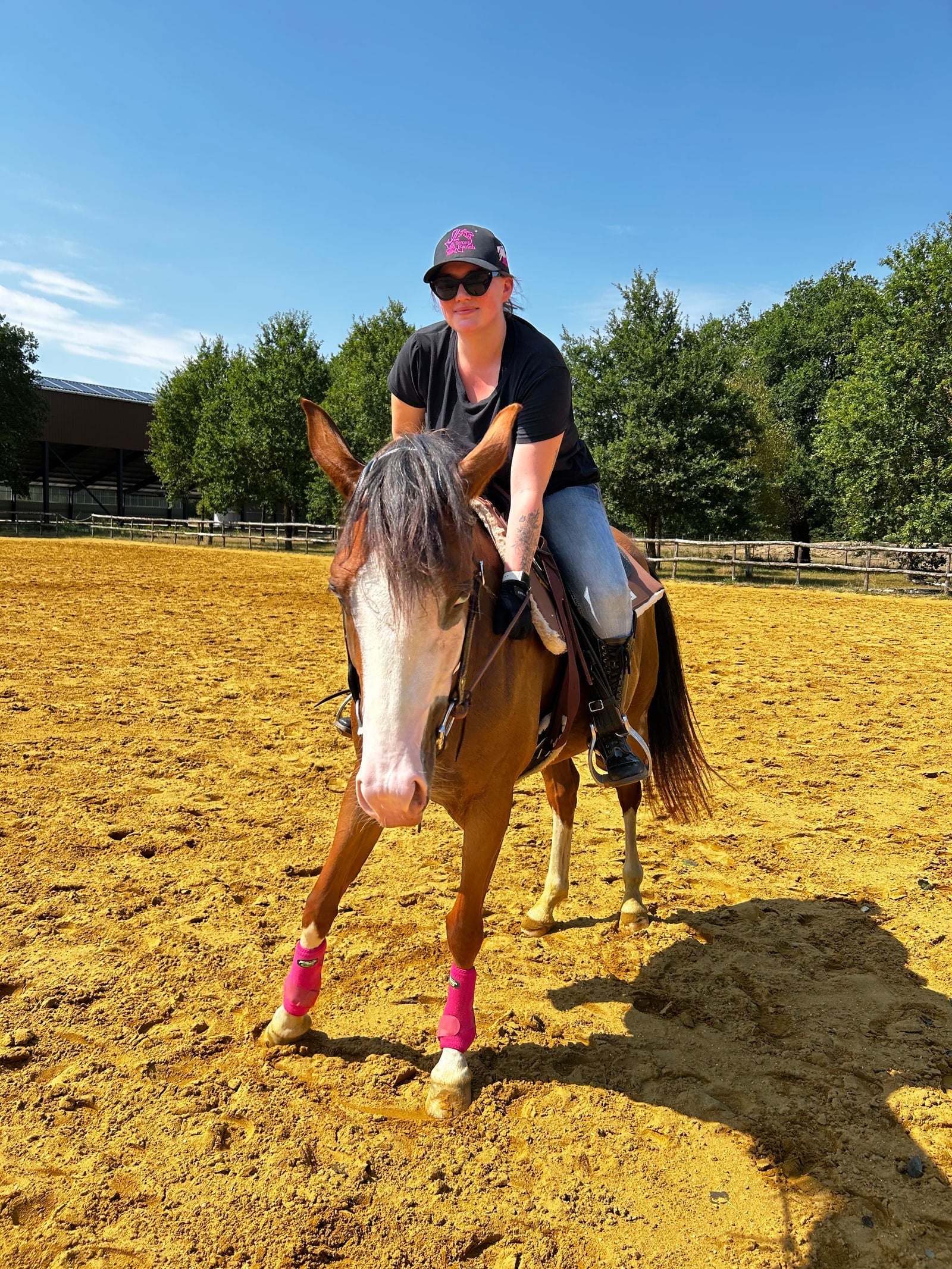 Camille Guignon à cheval dans une arène extérieure ensoleillée